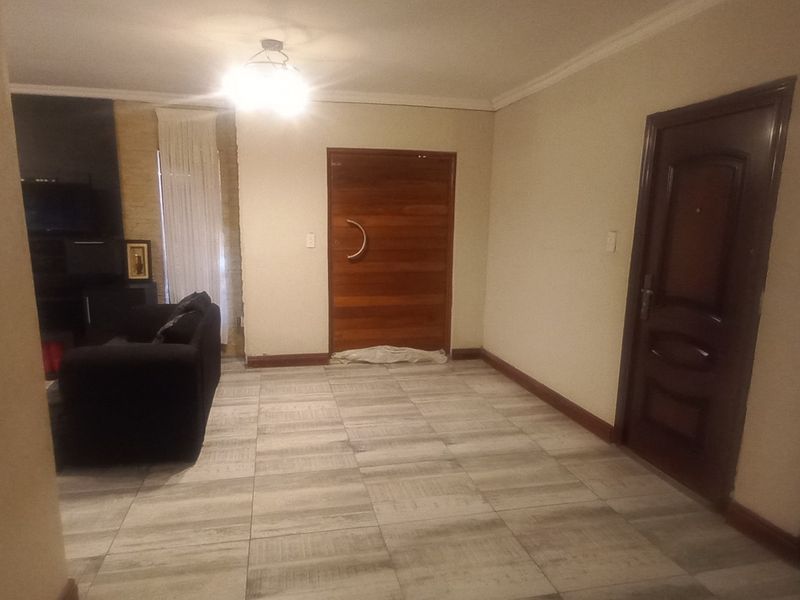 An entry area featuring tiled flooring, a solid wooden front door, and an additional internal door, with some minor finishing work required.