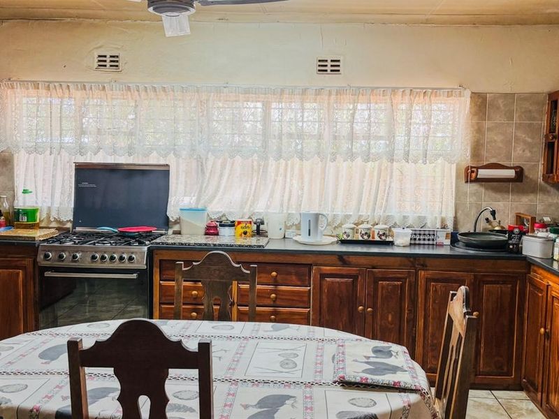 A functional kitchen featuring traditional wooden cabinetry, a gas stove, and tiled backsplash, offering a classic layout with ample storage and workspace.