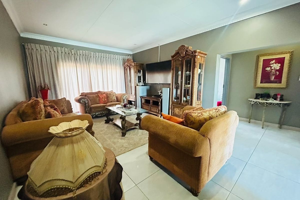 Spacious living room featuring large format floor tiles, recessed ceiling lighting, and decorative coved cornicing, providing a neutral foundation for various interior styles.