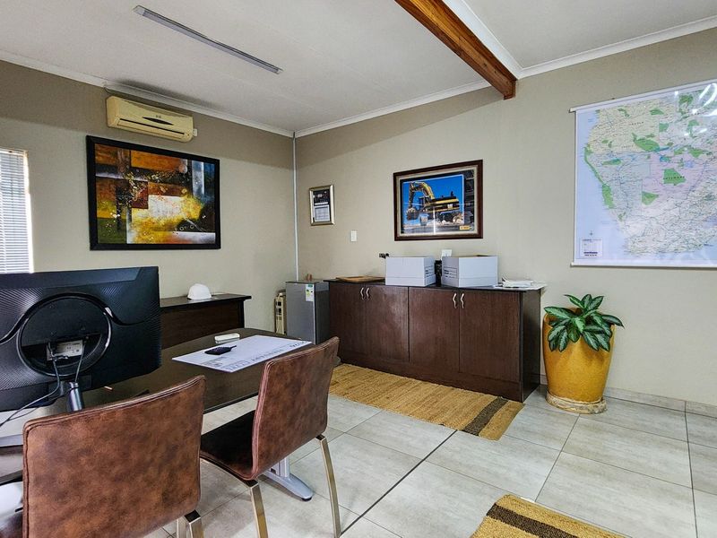 A functional commercial office space featuring tiled flooring, built-in storage cabinetry, and a split-system air conditioning unit.