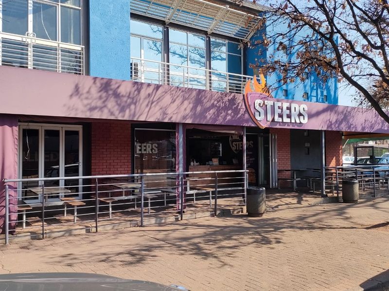 Front exterior view of a commercial office or retail space featuring a brick facade, metal railings, and a prominent storefront awning.