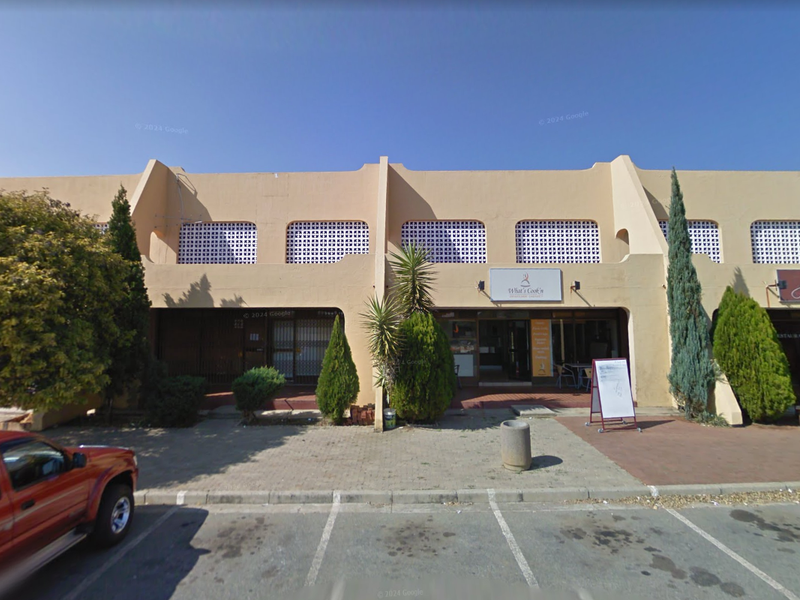 Front exterior view of a commercial restaurant complex featuring a paved parking area and distinctive architectural concrete buttresses.