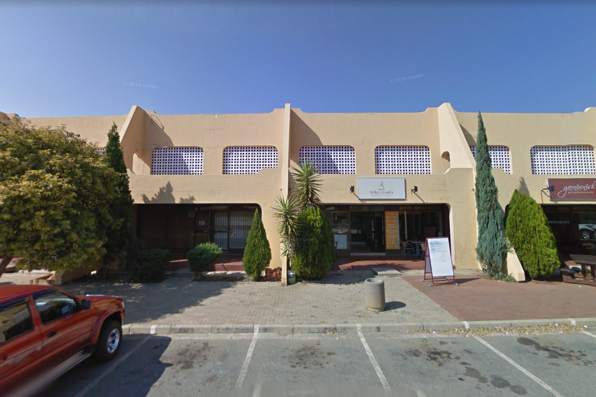 Front exterior view of a commercial restaurant complex featuring a paved parking area and distinctive architectural concrete buttresses.