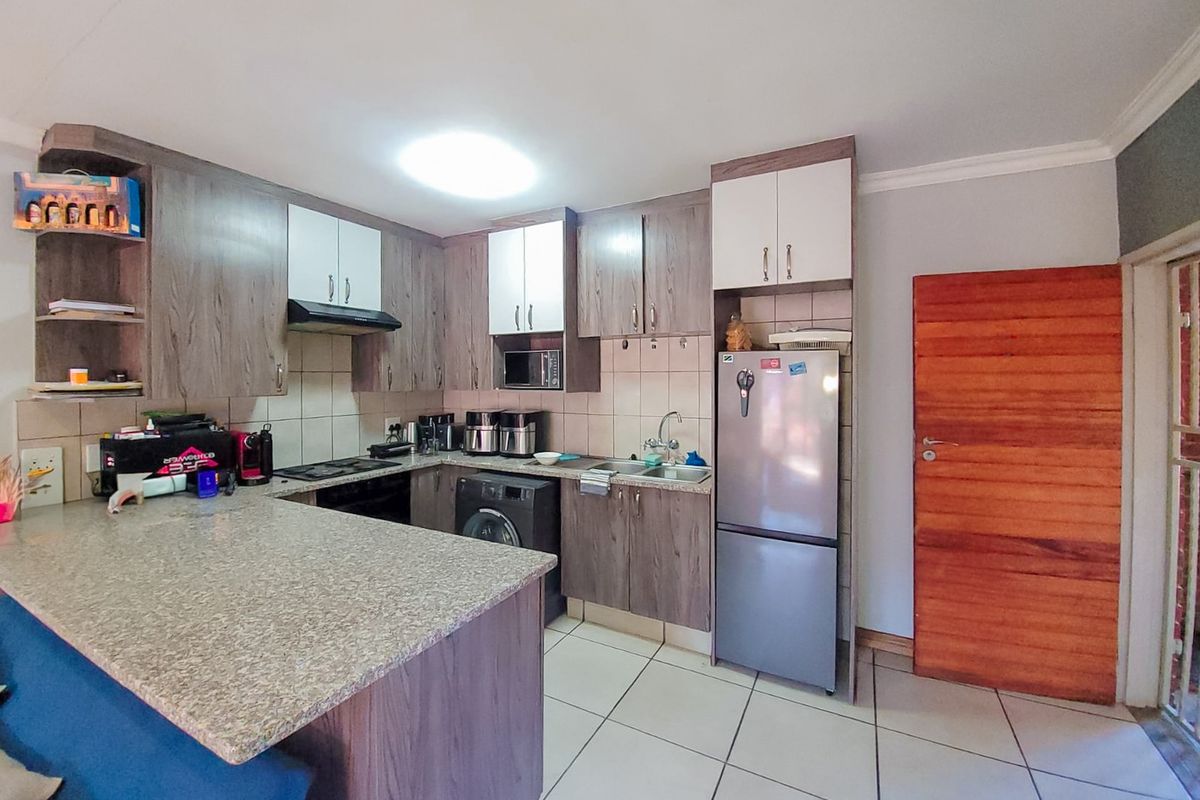 Functional kitchen featuring laminate cabinetry, granite countertops, built-in appliances, and tiled flooring, offering a practical layout for daily cooking and preparation.