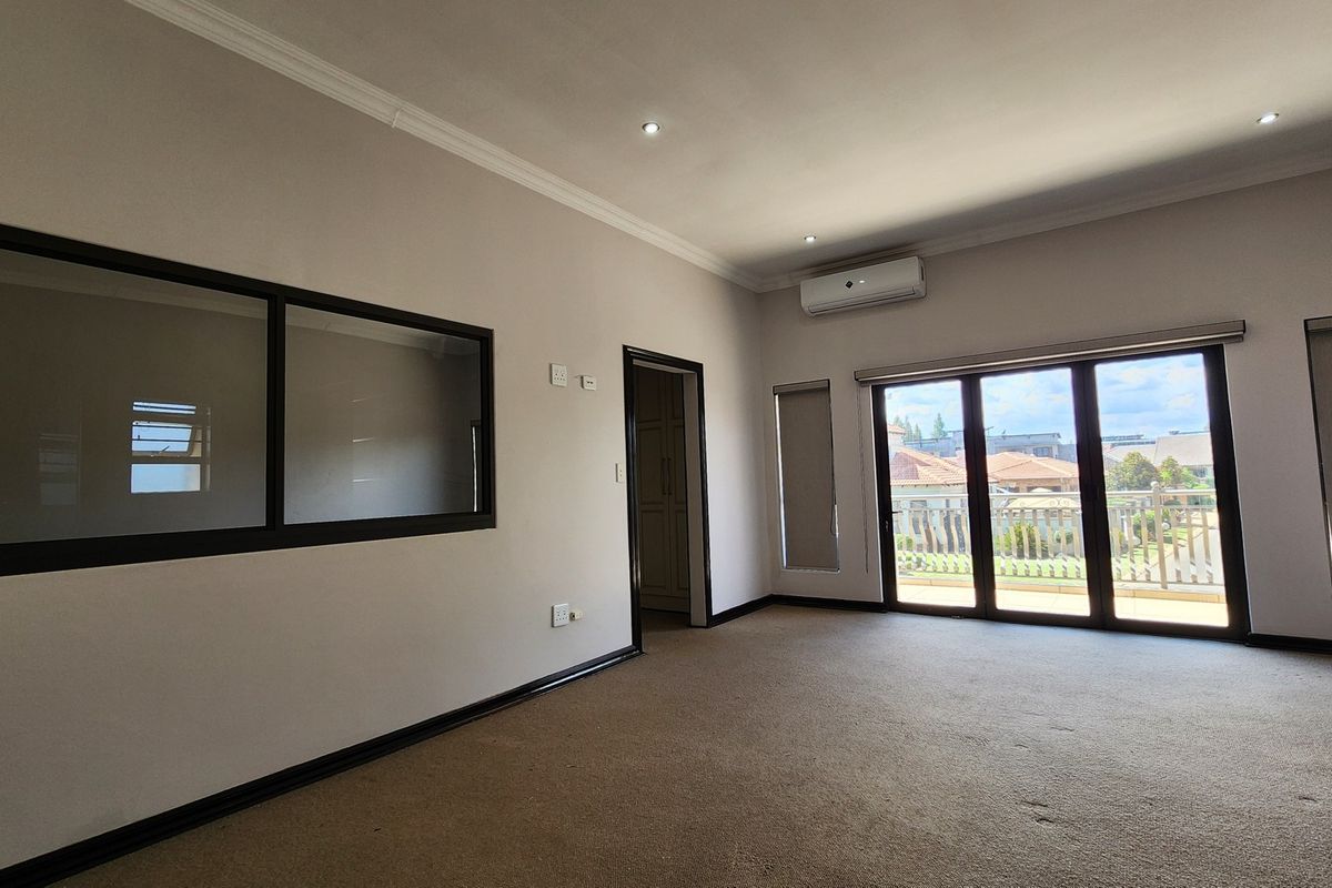 Spacious living area featuring neutral walls, carpet flooring, recessed lighting, air conditioning, and large sliding glass doors leading to an outdoor balcony.