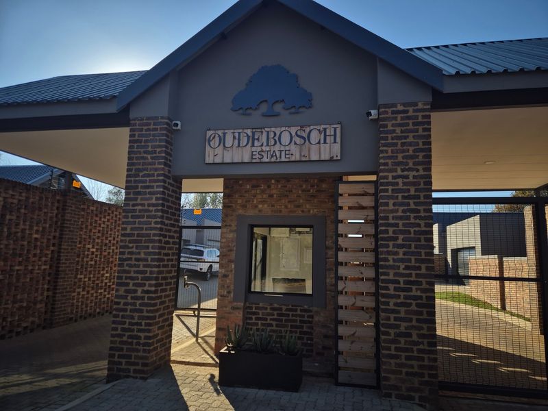The main entrance gate and security guardhouse of Oudebosch Estate, featuring modern brickwork, secure access gates, and clear estate signage.