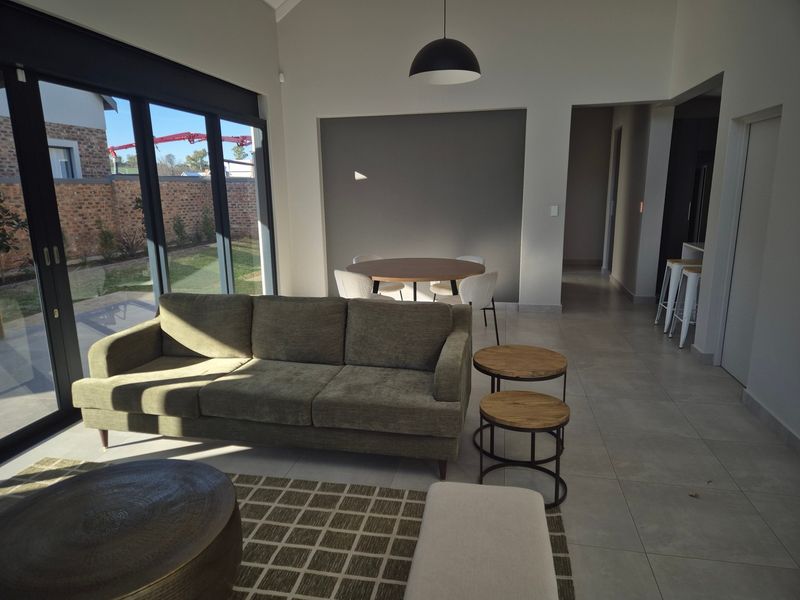 Spacious open-plan living and dining area featuring large sliding glass doors that provide seamless access to the garden and abundant natural light.
