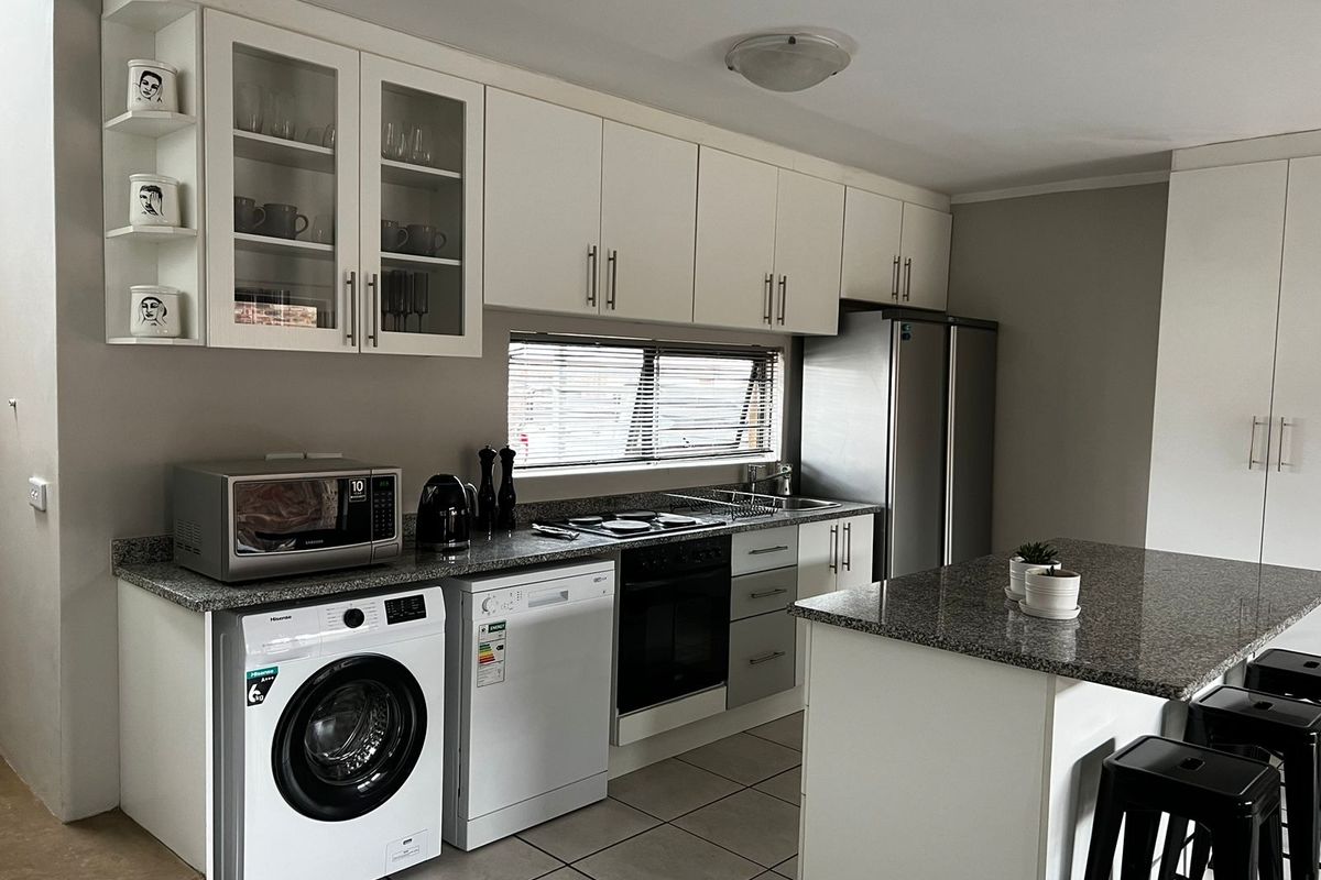 Modern kitchen featuring granite countertops, ample cabinetry, integrated appliances, and a functional island layout, providing a clean and efficient workspace.