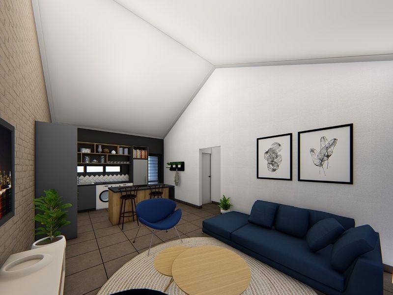 Modern open-plan living area featuring a vaulted ceiling, exposed brick wall, and a compact kitchen with built-in cabinetry and island.