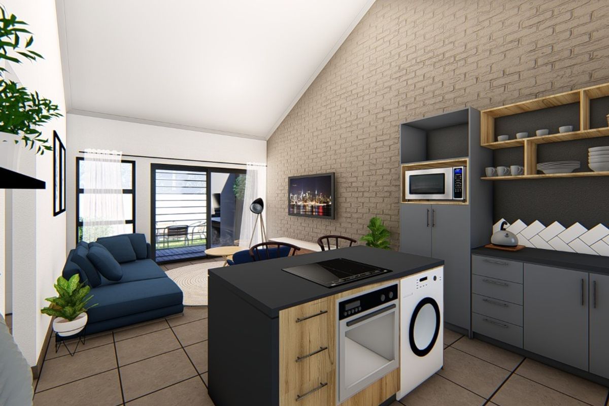 Modern open-plan living area featuring a vaulted ceiling, exposed brick wall, and a contemporary kitchen island with integrated appliances and tiled flooring.