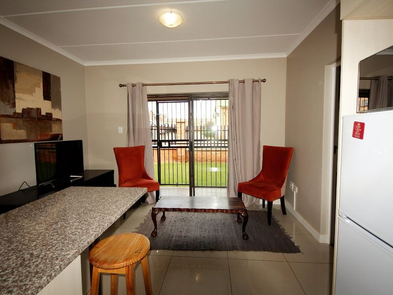 Open-plan living area featuring tiled floors, a granite breakfast counter, and sliding glass doors providing direct access to the outdoor space.