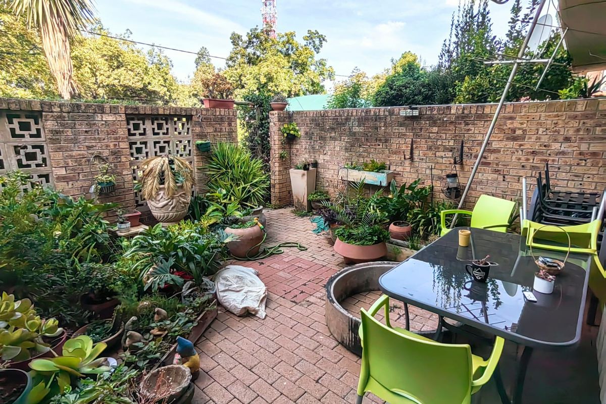 A private rear courtyard featuring brick boundary walls with decorative breeze blocks and paved flooring, offering a secluded outdoor space.