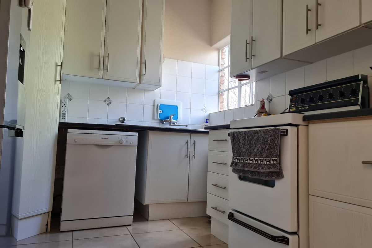 A functional kitchen featuring white cabinetry, tiled backsplash, tiled flooring, and built-in appliances including a stove and dishwasher.
