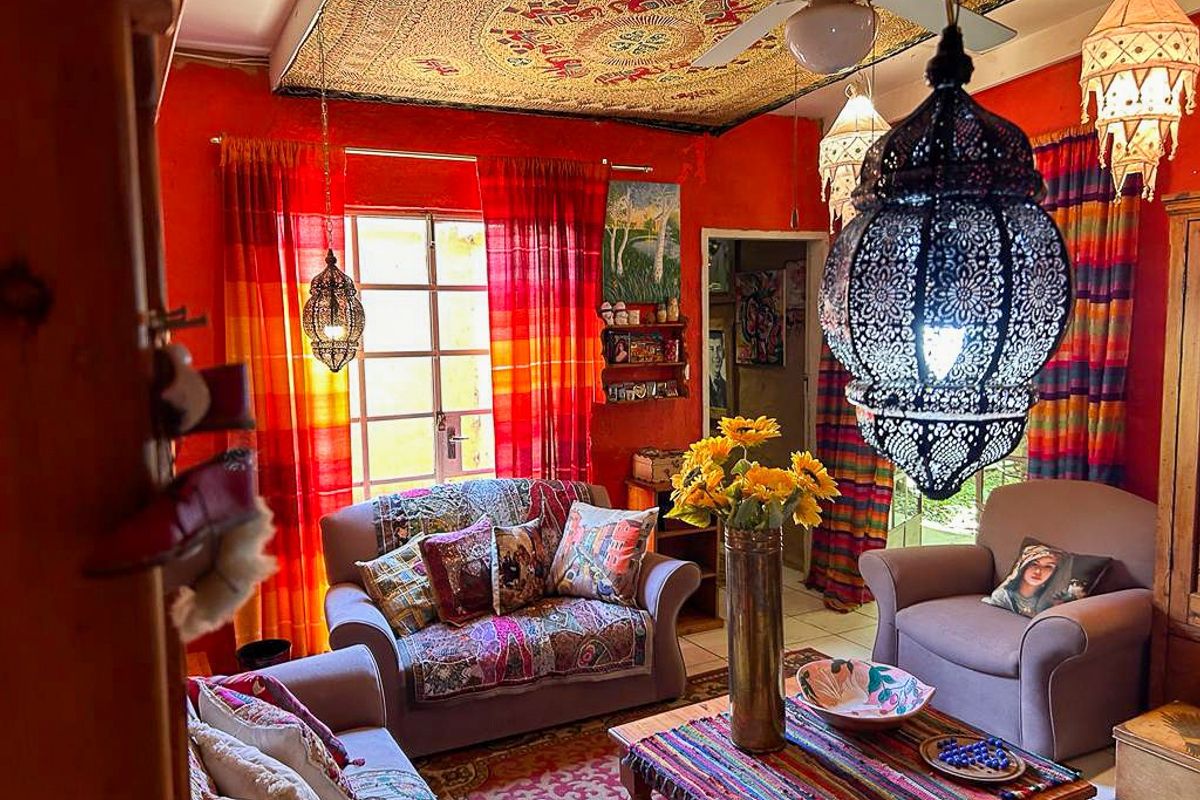 A vibrant living room featuring a ceiling fan, decorative ceiling treatment, and large windows allowing natural light into the space.
