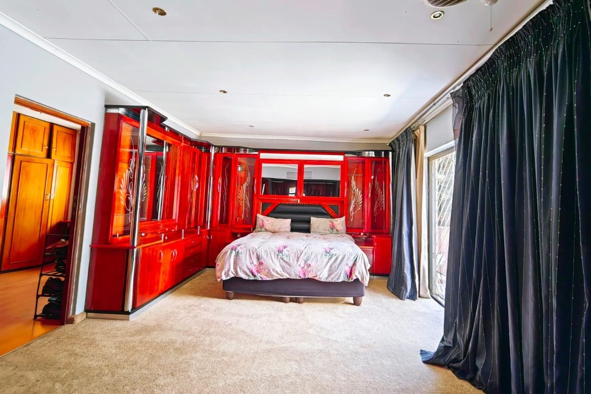 Spacious bedroom featuring extensive built-in cabinetry, recessed ceiling lighting, and sliding glass doors providing access to the exterior.
