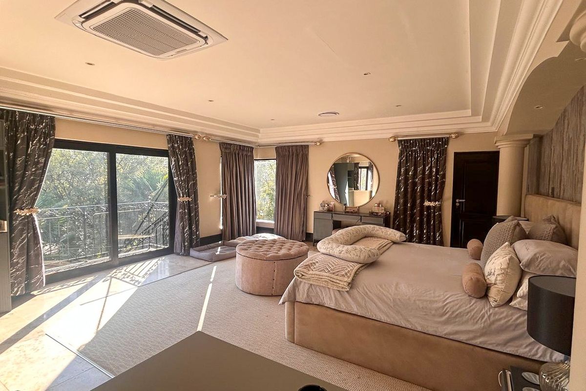 Spacious primary bedroom featuring recessed ceiling lighting, integrated air conditioning unit, and large sliding glass doors opening onto a private balcony.