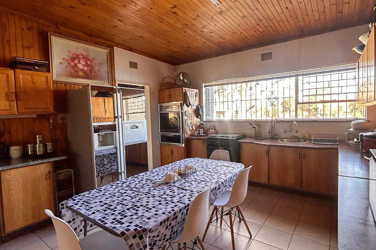 Spacious kitchen featuring wooden cabinetry, built-in oven, and tiled flooring, offering a functional layout with ample counter space and natural light.