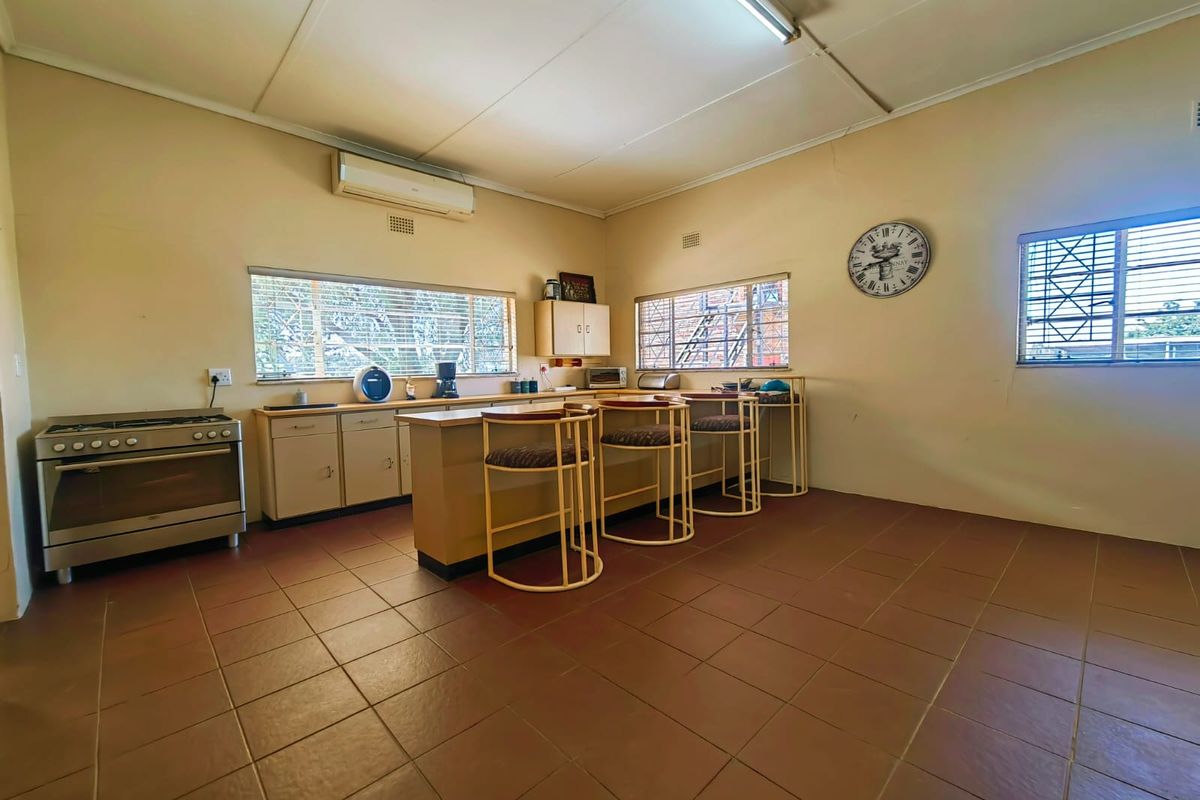 Spacious kitchen featuring a central breakfast island, built-in cabinetry, tiled flooring, and a wall-mounted air conditioning unit.