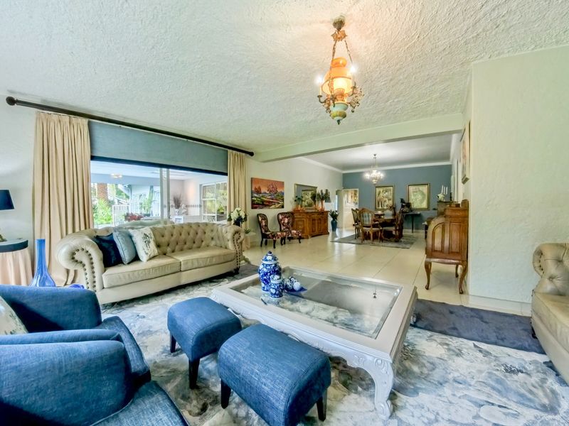 Spacious open-plan living and dining area featuring tiled flooring, textured ceilings, and large sliding glass doors providing access to the outdoor space.