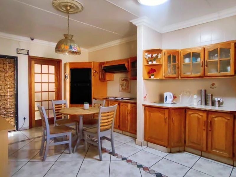 A functional kitchen featuring traditional wooden cabinetry, laminate countertops, and tiled flooring, offering a classic layout with potential for modern updates.