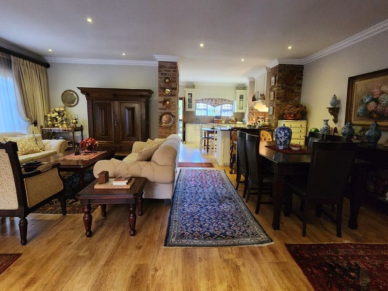 Spacious open-plan living and dining area featuring exposed brick pillars, recessed lighting, and seamless flow into the kitchen space.