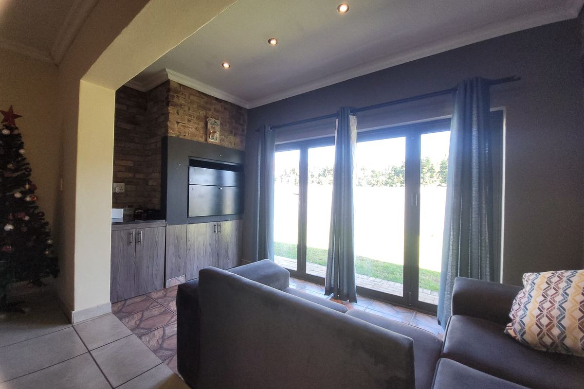 A living room featuring a brick fireplace, built-in cabinetry, and large sliding glass doors that provide direct access to the outdoor area.