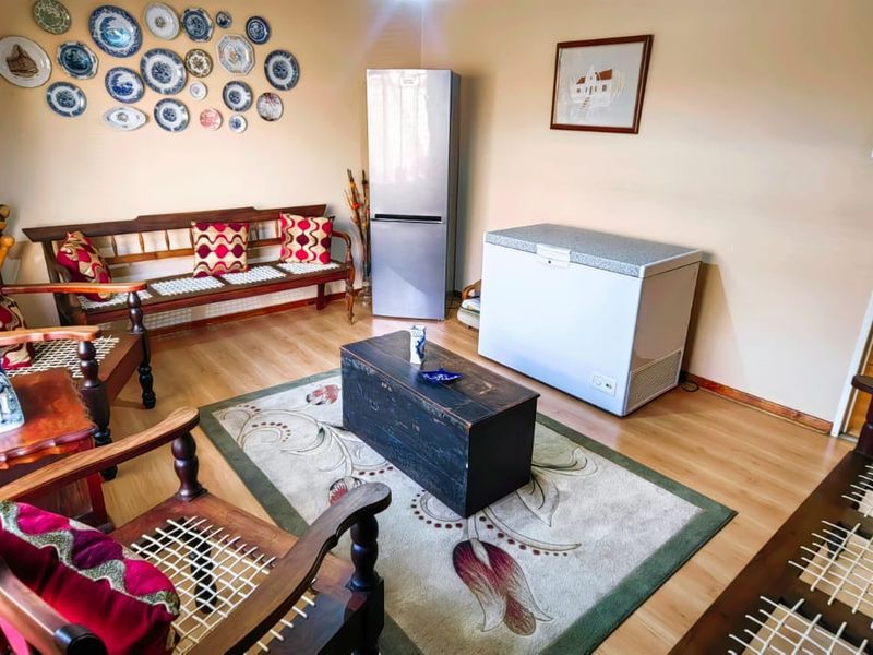 A living area featuring laminate flooring and window blinds, providing a functional space with potential for modern updates.