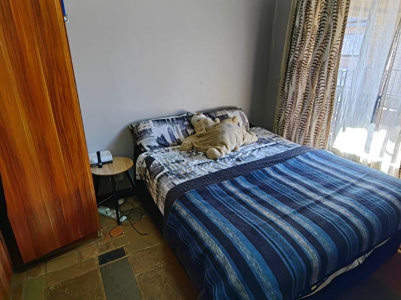 A bedroom featuring a built-in wardrobe and a sliding glass door providing access to an outdoor area.
