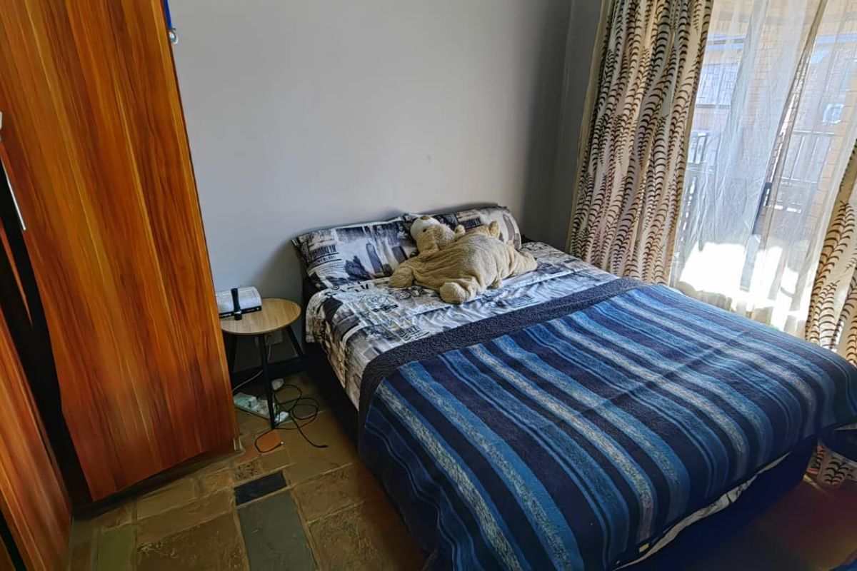 A bedroom featuring a built-in wardrobe and a sliding glass door providing access to an outdoor area.