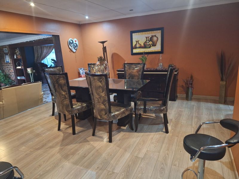 A dining room featuring laminate flooring and recessed ceiling lighting, providing a functional space for family meals and entertaining.