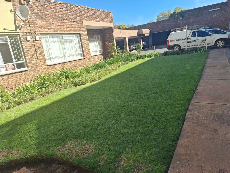 Front exterior view of the apartment building featuring a face brick facade, well-maintained lawn, and paved walkway.