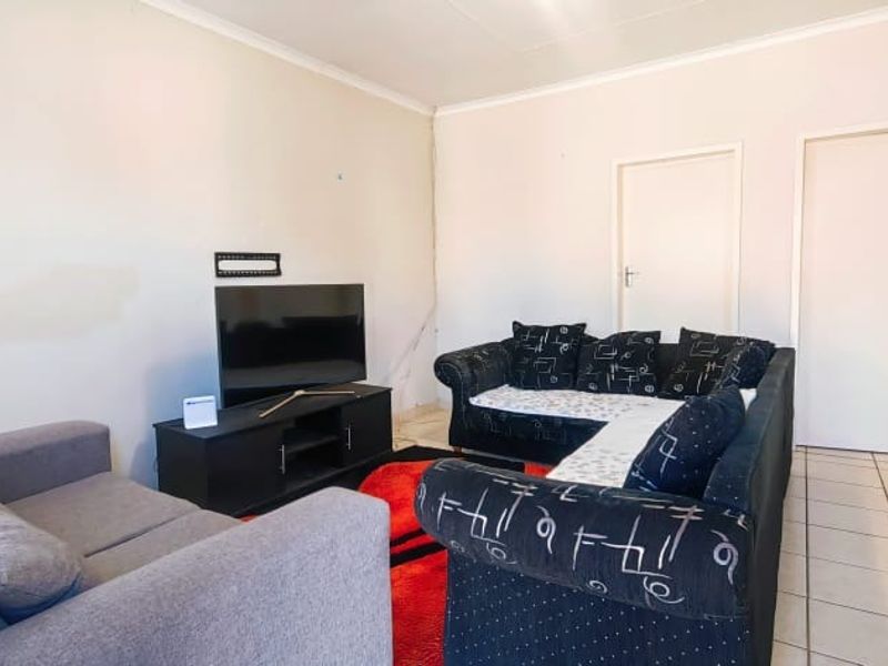 A living room area featuring tiled flooring and neutral wall finishes, providing a functional space for relaxation.