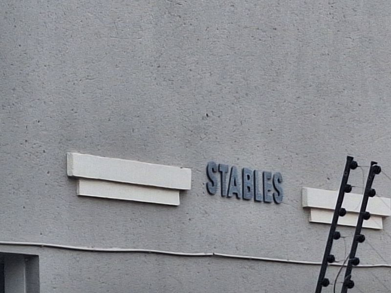 A close-up view of the building facade featuring textured plaster finish and installed electric security fencing.