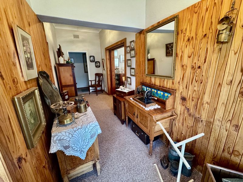 A traditional hallway featuring timber wall paneling and carpeted flooring, connecting multiple rooms within the home.