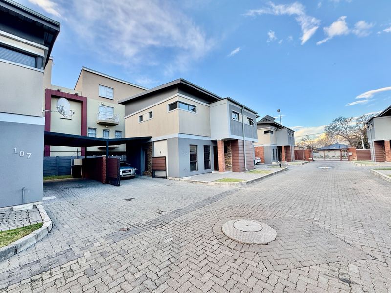 Modern apartment complex exterior featuring paved driveways, covered parking bays, and contemporary architectural facade finishes.