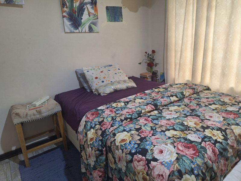 A bedroom featuring tiled flooring and neutral wall finishes, providing a functional space for rest.