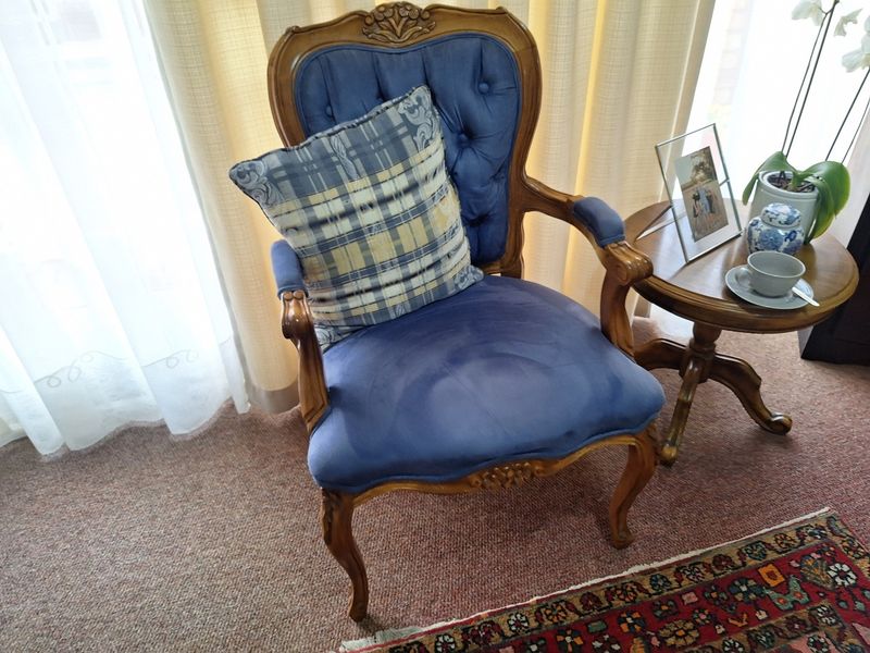 A corner of a living area featuring carpeted flooring and window curtains.