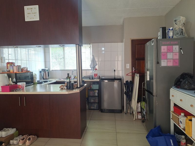 A functional kitchen featuring laminate countertops, built-in cabinetry, tiled backsplash, and tiled flooring, offering a practical layout for daily use.