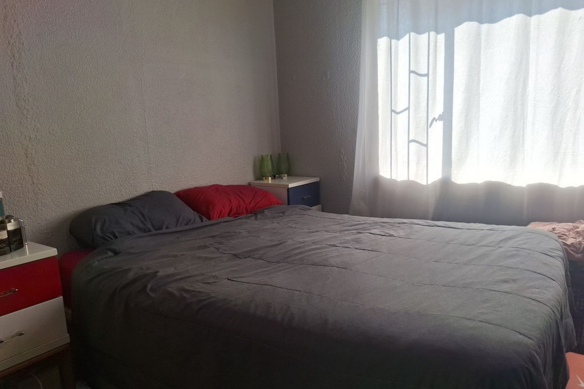 A standard bedroom featuring a window with natural light, providing a functional space for rest.