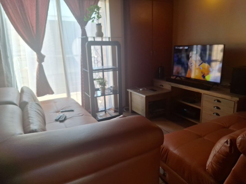 A living room area featuring a built-in cupboard and a sliding glass door leading to an outdoor space.