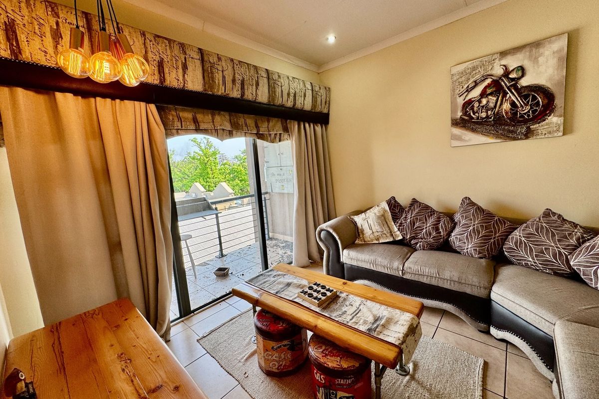 A living room featuring tiled flooring, recessed lighting, and a sliding glass door providing access to an outdoor balcony area.