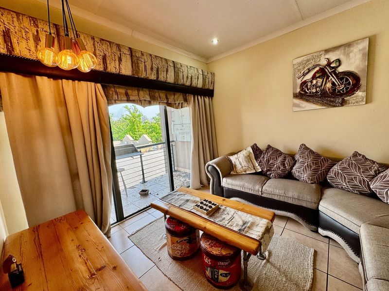 A living room featuring tiled flooring, recessed lighting, and a sliding glass door providing access to an outdoor balcony area.