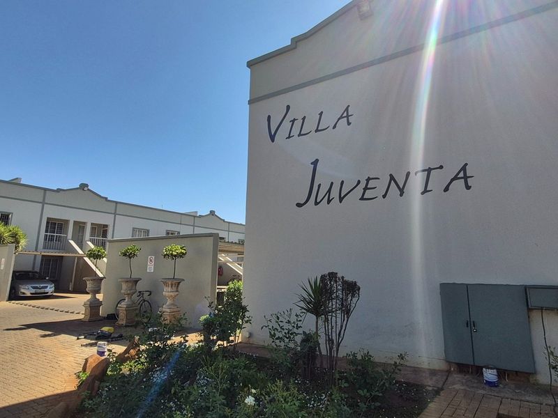Exterior view of the Villa Juventa apartment complex entrance, featuring paved driveway access and established landscaping.