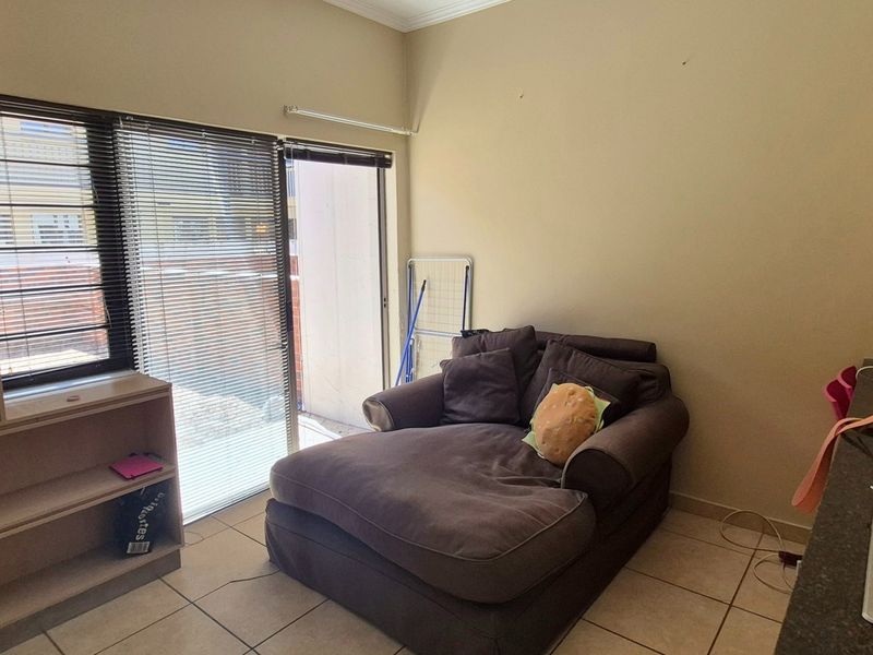 Open plan living area featuring tiled flooring, built-in shelving, and a sliding door providing access to the exterior.