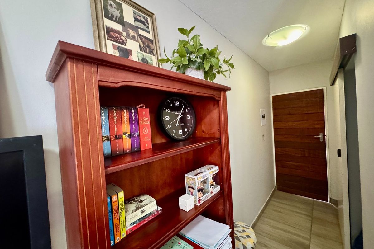 A functional hallway featuring tiled flooring, a wooden door, and a flush mount ceiling light.