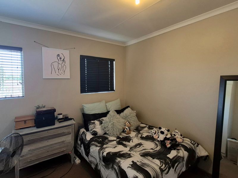 A standard bedroom featuring neutral wall finishes, venetian blinds, and cove cornicing, providing a functional and well-lit sleeping space.