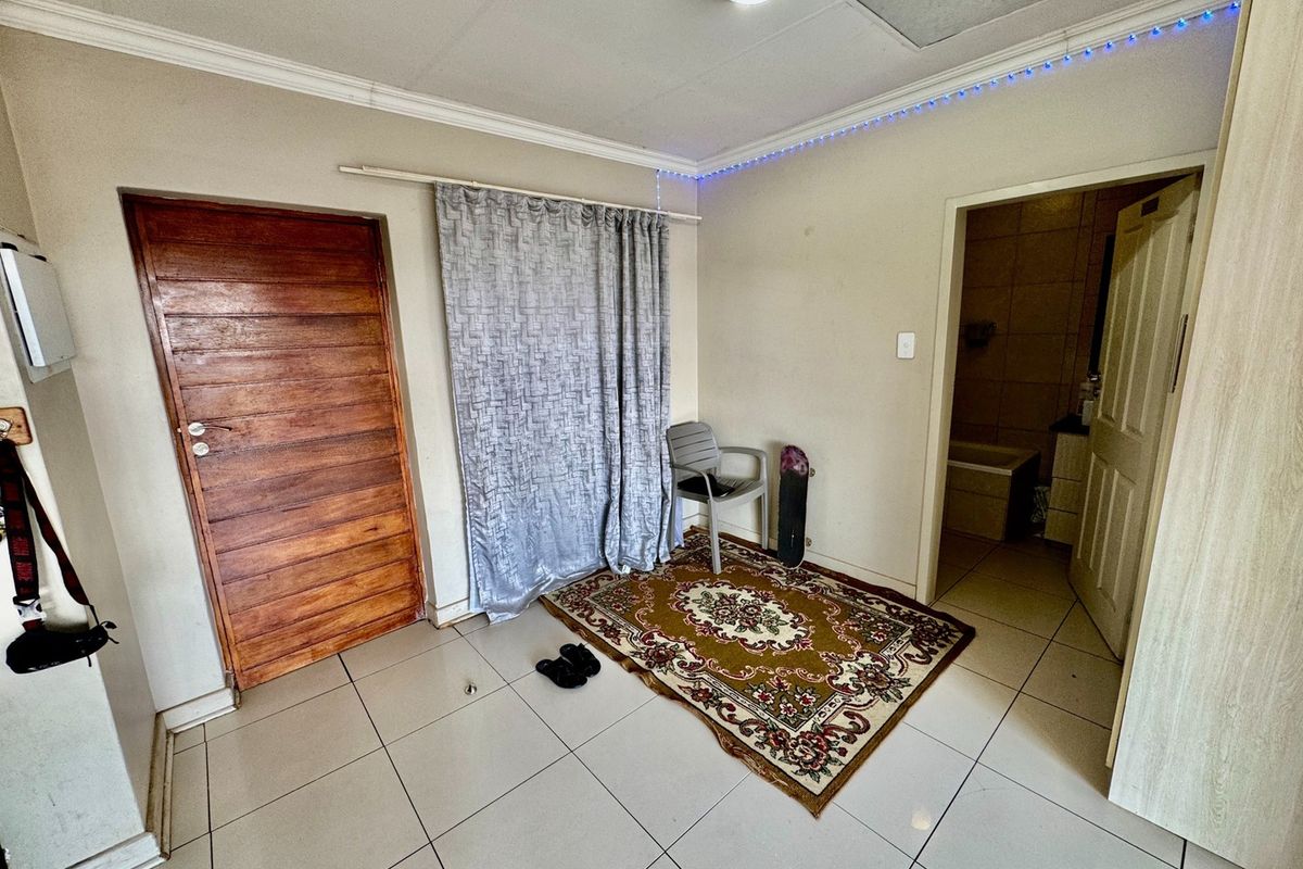 A bedroom featuring tiled flooring, ceiling cornice, and direct access to an en-suite bathroom.