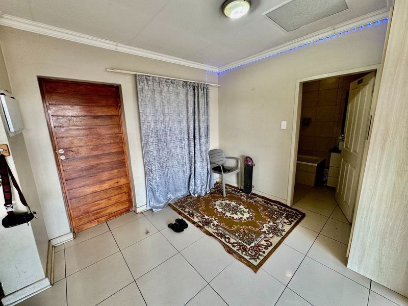 A bedroom featuring tiled flooring, ceiling cornice, and direct access to an en-suite bathroom.
