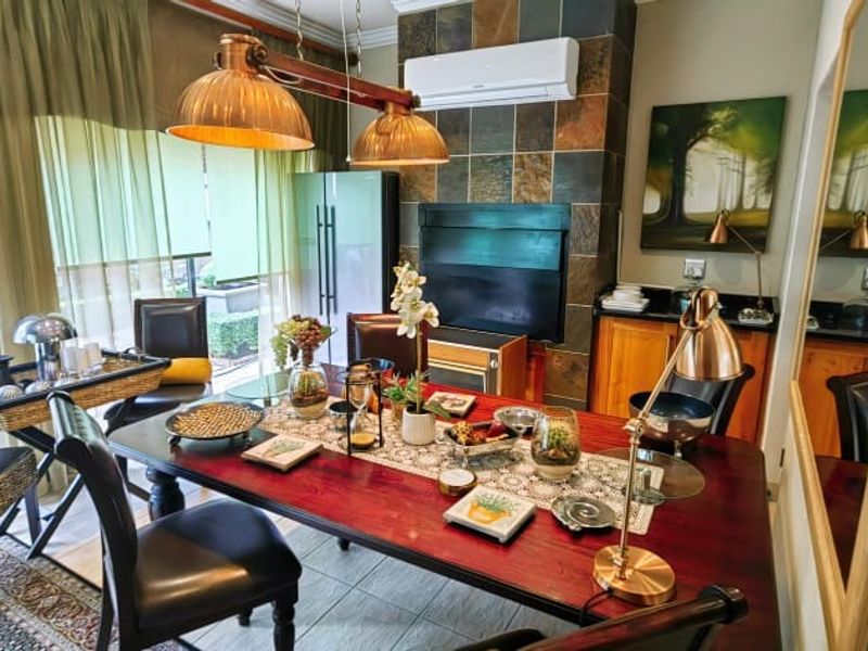 Dining room featuring tiled flooring, a slate-tiled fireplace surround, split-system air conditioning, and sliding glass doors providing access to the outdoor area.