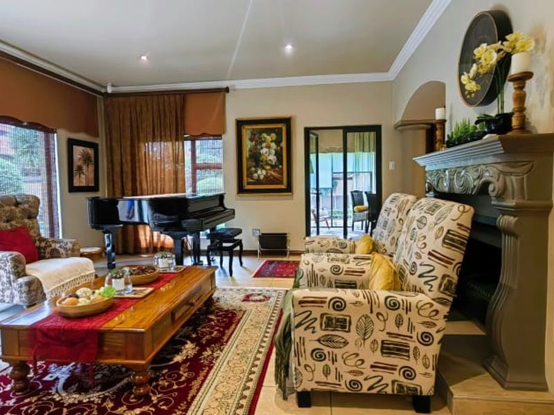 Spacious living room featuring a decorative fireplace, tiled flooring, and large sliding glass doors providing access to the outdoor area.